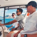 Captain and guests at the helm of Mana Kahi