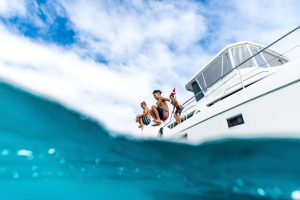 Boys jumping off the side of MANA Cruises' Waikiki vessel, The HILINA'I